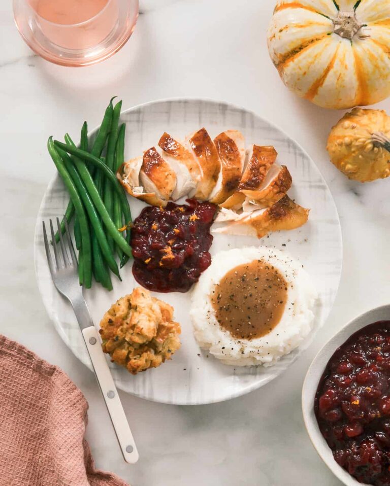 टर्की, क्रैनबेरी सॉस, मसले हुए आलू और हरी बीन्स के साथ थैंक्सगिविंग दावत की प्लेट।