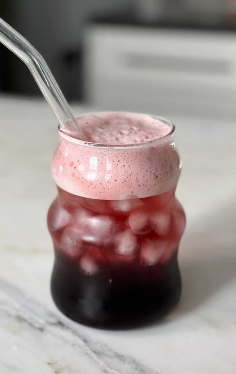 नींद की लड़की एक भूसे के साथ एक गिलास में मॉकटेल करती है।