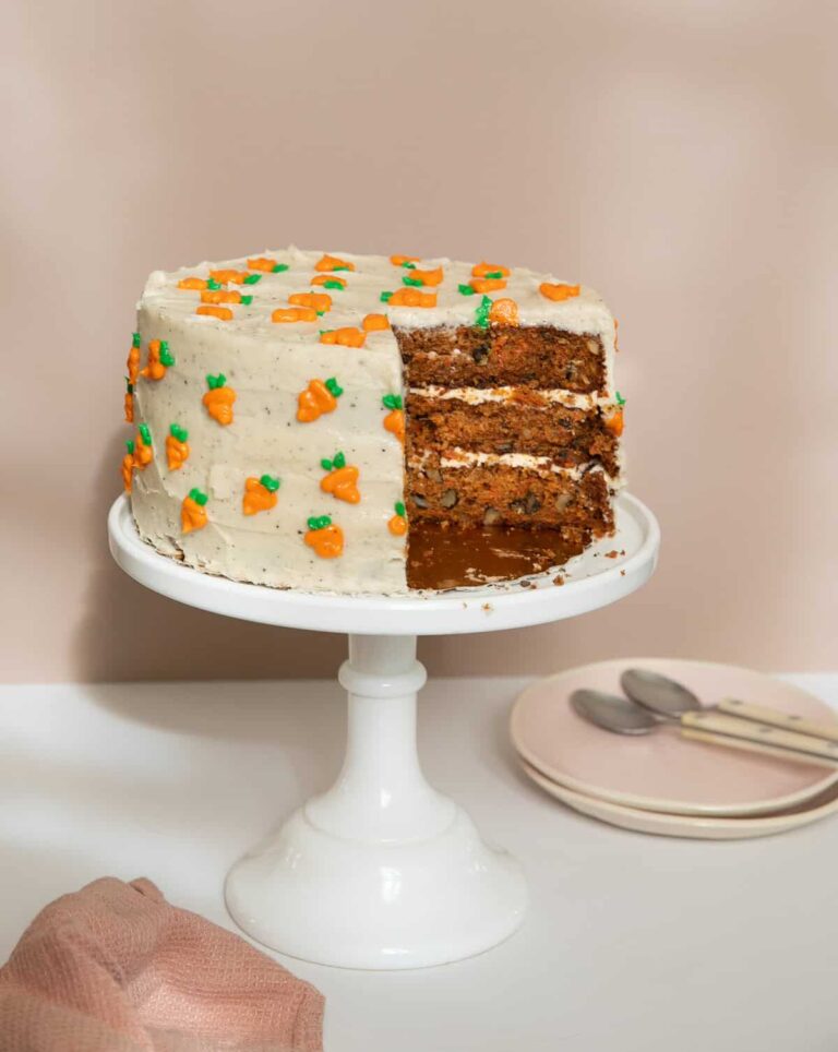 केक पर गाजर केक प्लेटों और चम्मच के साथ एक केक स्टैंड पर।