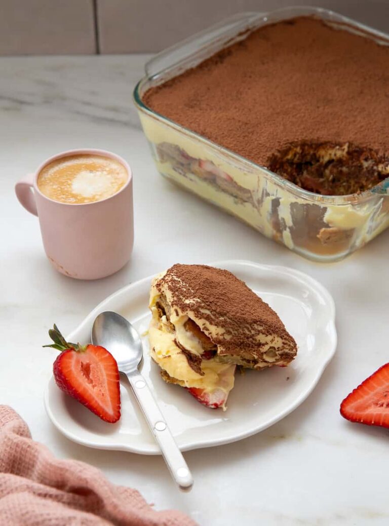 दुबई चॉकलेट तिरामिसु एक प्लेट पर पीठ में मुख्य पकवान के साथ।