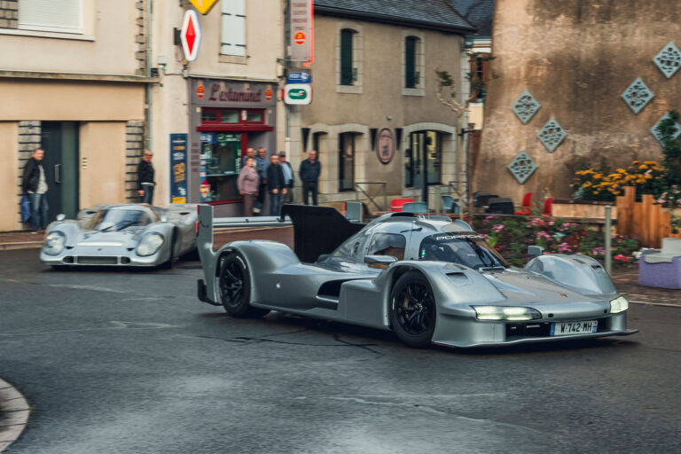 porsche-963-rsp-with-917-driving-through-town-front-quarter-tracking.jpg