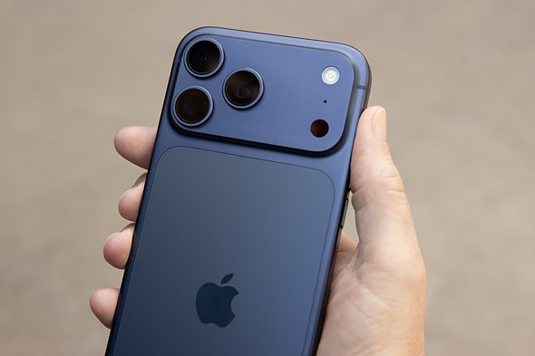 The_back_of_a_blue_iPhone_17_Pro_Max_held_in_a_hand_showing_the_cameras_and_Apple_logo.jpeg