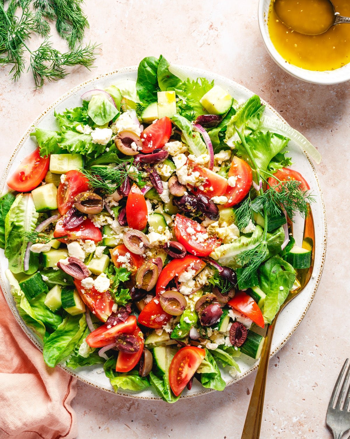 ड्रेसिंग के साथ प्लेट पर मेडिटेरेनियन सलाद।