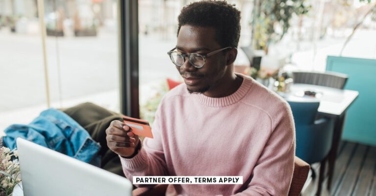 SOCIAL-IMAGE_PARTNER-OFFERS-TERMS-APPLY_Man-sitting-at-cafe-using-laptop-and-holding-credit-card_MixMedia_21.jpg