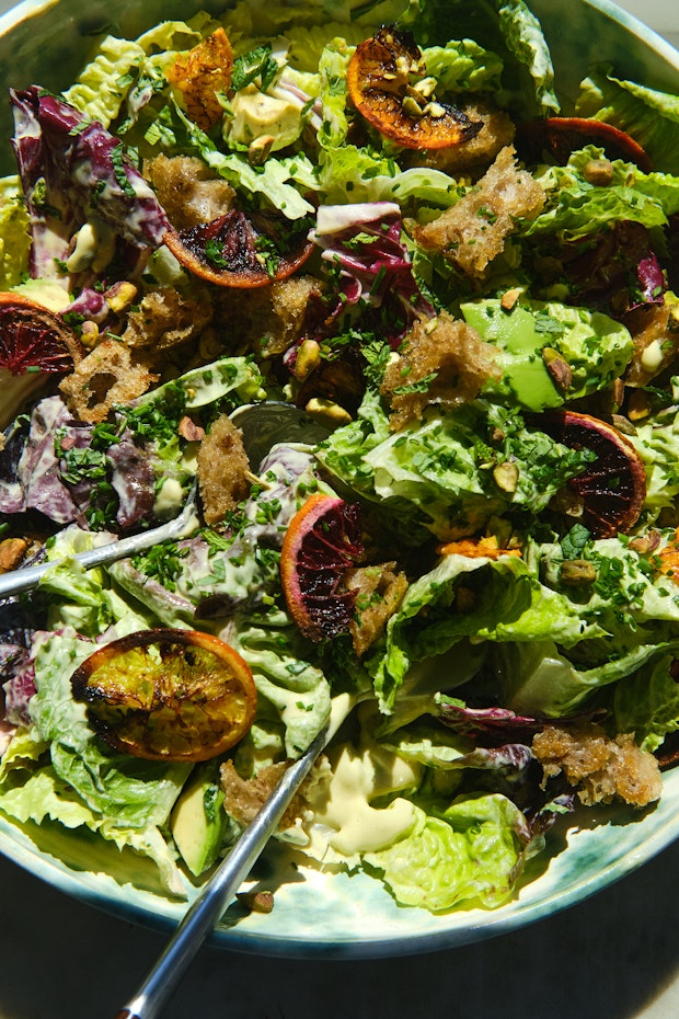 सलाद चिमटे के साथ एक बड़े कटोरे में सीज़र सलाद