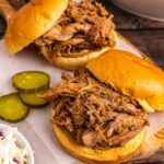 खींचे गए पोर्क को लकड़ी के कटिंग बोर्ड पर गोल बन पर रखकर कटा हुआ अचार और कोलस्लॉ के साथ परोसा जाता है।